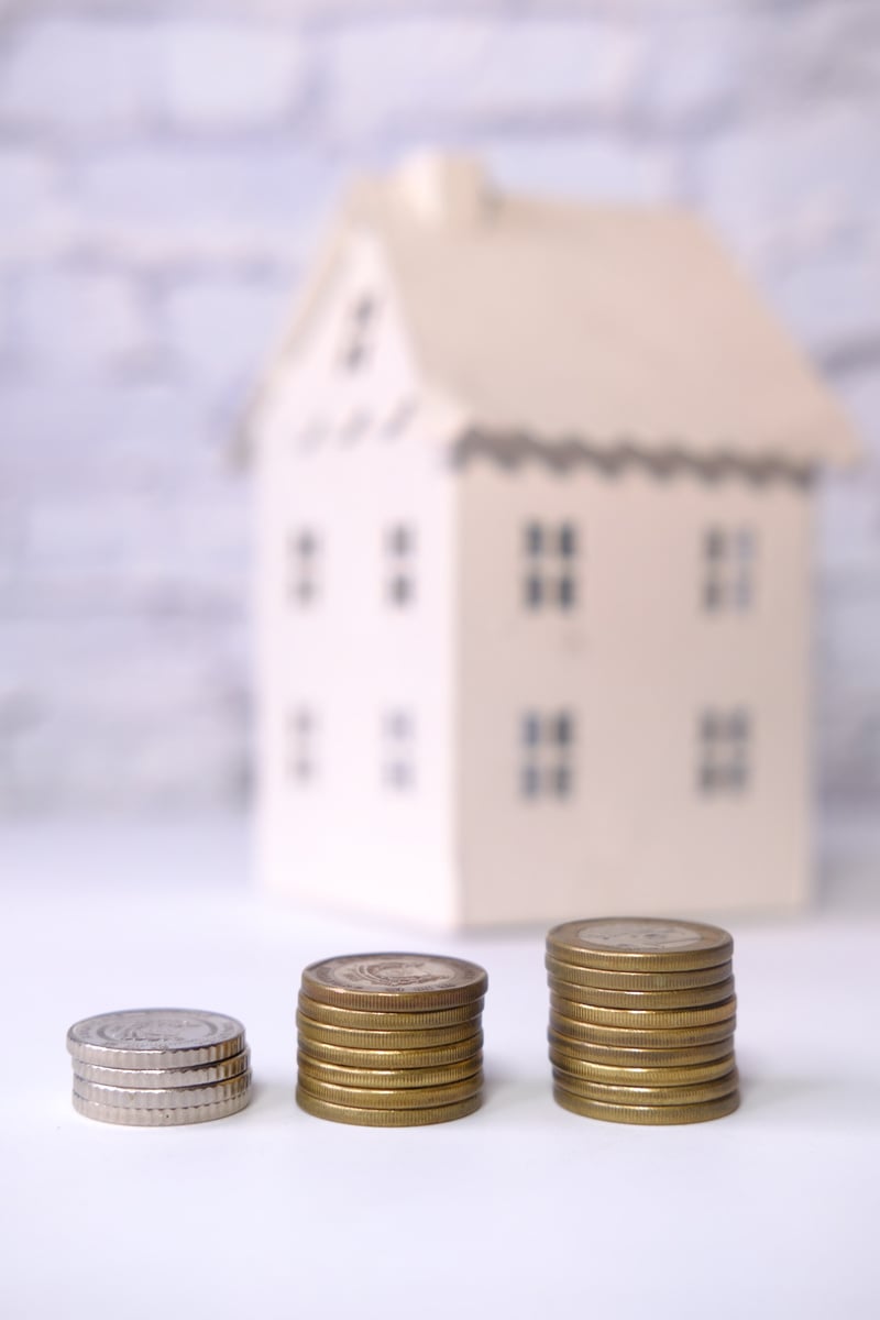 The Concept of Finance Concept with Stack of Coins and House on Table